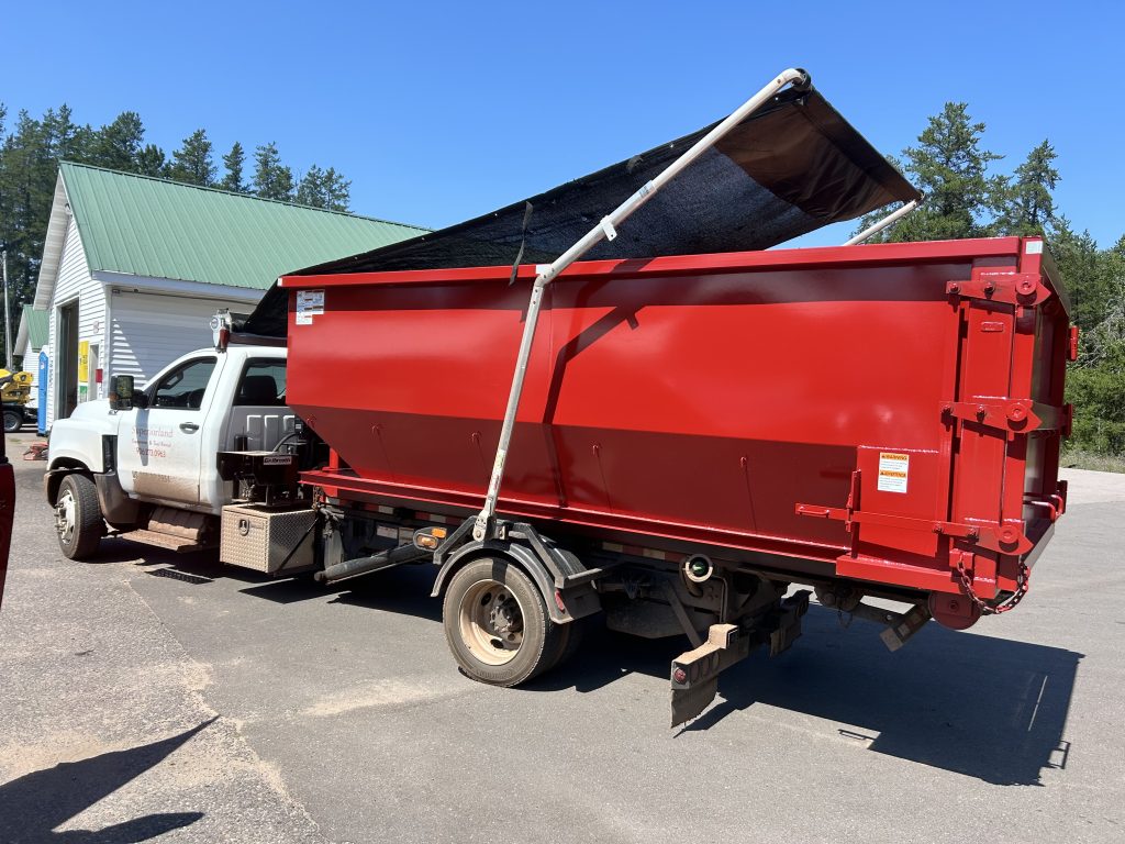 Close up of a 20 yard dumpster attacked to a truck.